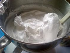 a metal bowl filled with whipped cream on top of a stove