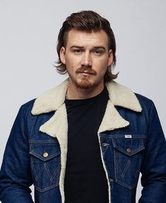 a man with long hair wearing a denim jacket