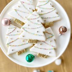 decorated christmas tree cookies on a white plate