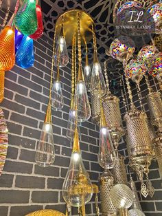 many colorful lights hanging from the ceiling in a room with brick wall and grey bricks