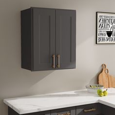 a kitchen with gray cabinets and white counter tops in front of a framed poster on the wall