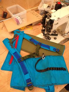 three pieces of blue fabric sitting on top of a table next to a sewing machine