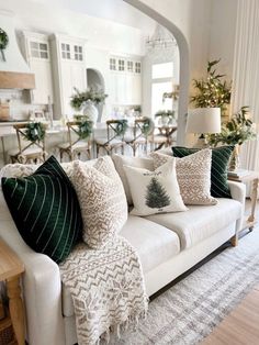 a living room filled with lots of furniture and pillows on top of a white couch