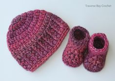 a crocheted hat, booties and beanie are laying on the table