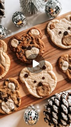 cookies are arranged on a wooden cutting board next to pine cones and christmas decorations,