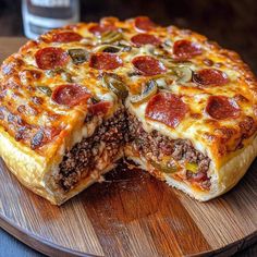 a deep dish pizza cut in half on a wooden platter