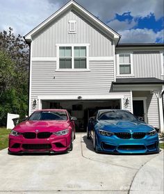 two bmws parked in front of a house with blue and pink paint on them