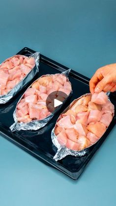 two trays filled with meat on top of a blue table