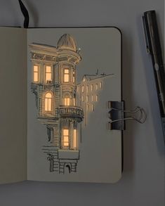 an open notebook with a drawing of a building on the cover and a pen next to it