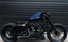 a black motorcycle parked in front of a garage door