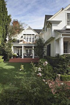 a large white house sitting on top of a lush green field