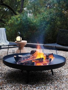 a fire pit sitting on top of a gravel field