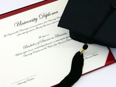 a graduation cap and diploma on top of a red folder with a black tassel