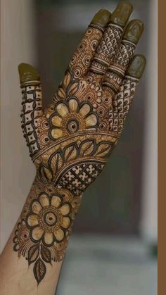 a woman's hand is decorated with henna and flower designs on the palm