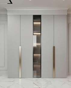 a white and gold closet in a room with marble flooring, two doors on each side