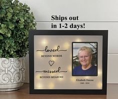 a photo frame with the words loved beyond words is shown next to a potted plant