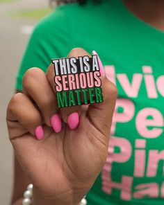 this is a serious matter pin on a woman's green t - shirt that says, this is a serious matter