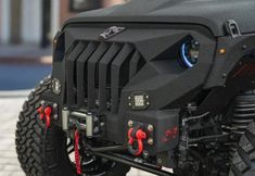 the front end of a large black vehicle with red handles and suspensions on it