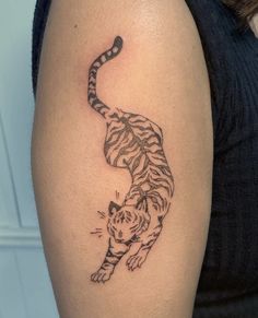 a woman with a tiger tattoo on her arm and the tail is curled up to show it's claws