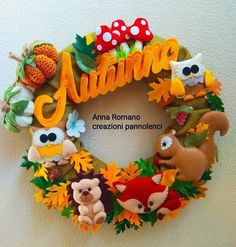 a wreath with stuffed animals on it and the word autumn written in spanish above them