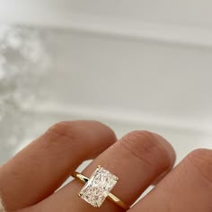 a woman's hand with a yellow gold ring on it and a diamond in the middle