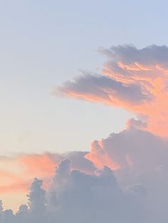 the airplane is flying high in the sky at sunset or dawn with clouds behind it