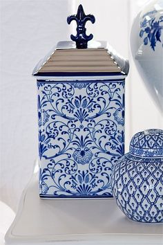 two blue and white vases sitting next to each other on top of a table