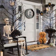 a porch decorated for halloween with skeletons and pumpkins