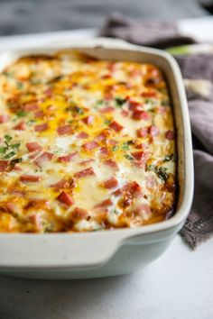 a casserole dish with ham, cheese and broccoli in it on a table