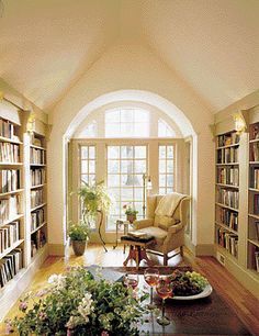 a living room filled with lots of books and furniture