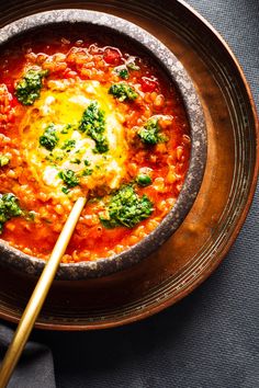 a bowl of soup with spinach and cheese