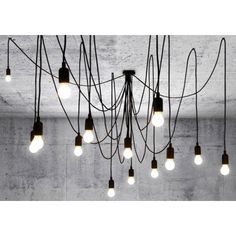 a bunch of light bulbs hanging from the ceiling in an empty room with concrete walls