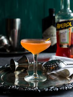 an orange drink sitting on top of a metal tray