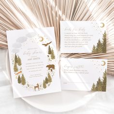 the wedding stationery is decorated with gold foil and white paper, along with forest animals