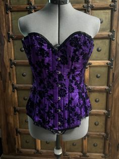 #006 - Purple satin steel boned corset, with black velvet flocked florals.  This corset will fit a waist 26 to 30 inches , bust 32 to 36" B-DD and 34 to 38 inch hips. Front measures 15.5 inches and 14 inch sides.  This is a long line waist training corset,  is made of 3 layers, cotton lined, waist tape and privacy panel with 2 part grommets. Gothic Strapless Costume Corset, Halloween Strapless Corset With Boned Bodice, Fitted Purple Corset Dress With Boned Bodice, Purple Overbust Corset Dress With Boned Bodice, Purple Underbust Corset Dress With Corset Back, Fitted Gothic Purple Corset, Purple Overbust Corset Dress With Corset Back, Purple Corset Dress With Underbust Design, Purple Underbust Corset Dress