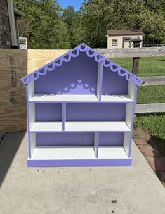 a doll house made out of bookshelves on the sidewalk