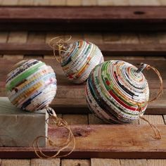 two balls of yarn sitting on top of a piece of wood next to a box