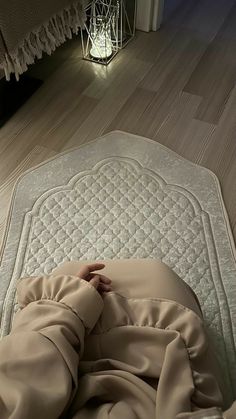 a person laying on top of a bed covered in a blanket