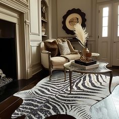 a living room with a zebra print rug on the floor next to a fire place