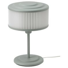 a light that is on top of a white table lamp with a cord attached to it