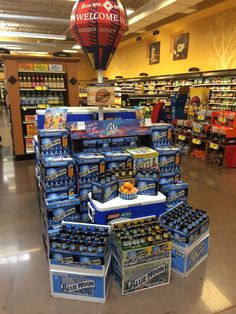 a large display in a store filled with bottles and boxes of beer on the floor