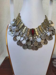 Afghan jewelry is famous for its beautiful and traditional handwork. The jewelry piece is embellished using a number of items such as metal nells, coins, stones, threads etc. these tribal jewelry sets share a link to their cultural values and traditions. This chunky set includes a heavily embellished coin choker. The arrangement of old coins on this whole set gives it a very classic traditional vibe. These handmade pieces can be a slightly bit different from the one in the image. This could be a Vintage Coin Necklaces For Festival, Handmade Antique Coin Necklace For Festival, Antique Handmade Coin Necklace For Festival, Handmade Metal Coin Necklace For Festival, Vintage Metal Coin Necklace, Handmade, Vintage Handmade Metal Coin Necklace, Bohemian Silver Choker In Brass, Antique Coin Pendant Necklace For Festivals, Vintage Silver Coin Necklace For Festivals