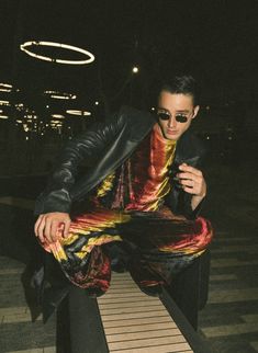 a man sitting on top of a wooden bench in front of a black and white checkered floor