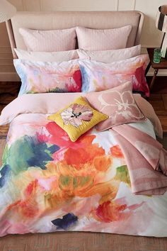 an image of a bed with colorful flowers on the comforter and pillowcases