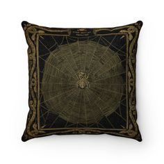 a black and gold pillow with a spider web design on it's front side