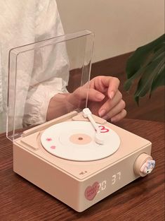 a person sitting at a table with an old fashioned record player in front of them