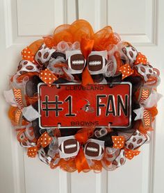 a football wreath with the number one fan on it and orange mesh netting around it