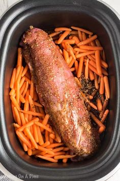 the meat and carrots are in the crockpot with seasoning on top