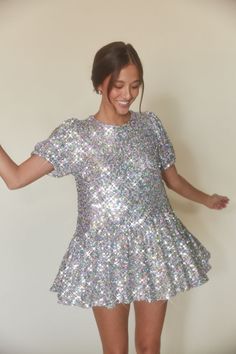 Dazzle everyone with your unforgettable style in the Elika Puff Sleeve Sequin Babydoll Mini Dress! This stunning dress features a babydoll silhouette, sparkling sequin embellishments, puff sleeves, crew neckline, ruffle hem, and a back tie detail. Pair with a classic heel to complete the look! Details Self: 90% Polyester, 10% Spandex; Contrast: 95% Polyester, 5% Spandex Lining: 100% Polyester Fully lined Hand wash cold / Hang dry Sequin Babydoll Dress, Sparkle Tights, Babydoll Mini Dress, Pink Sparkly, Short And Sweet, Holiday Dress, Puffed Sleeves Dress, Silver Dress, Sweet Style