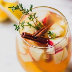 a glass filled with apple cider and cinnamon sticks